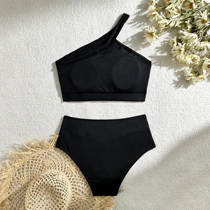 Detailed flat lay of black ribbed bikini set with chic one shoulder top and high waist bottom