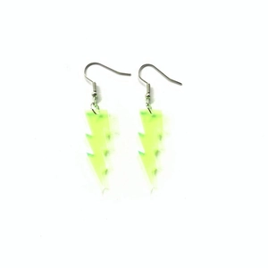 Detailed view of neon green glitter lightning bolt earrings made of acrylic and metal
