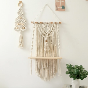 Detail view of Bohemian macrame wall shelf with cotton rope fringes and wooden board