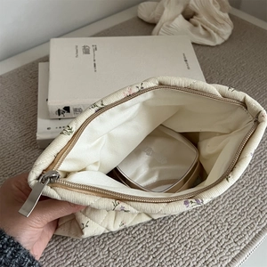 Detailed interior of a quilted corduroy floral makeup bag showing storage capacity