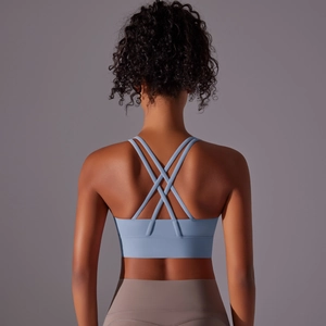 Dettaglio del reggiseno sportivo azzurro con spalline incrociate e fascia sottoseno larga