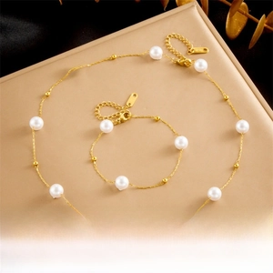 Detail of gold chain necklace and bracelet set with white pearls and K18 engraving