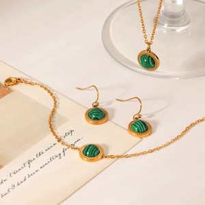 Detail of gold necklace, bracelet and earrings set with green malachite gemstones