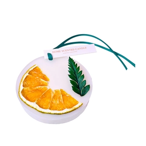 Handmade wax sachet with dried orange slice and green ribbon for home fragrance