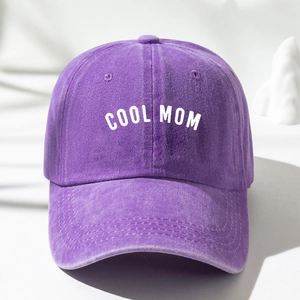 Close-up of a purple washed cotton baseball cap with white COOL MOM print and stitching