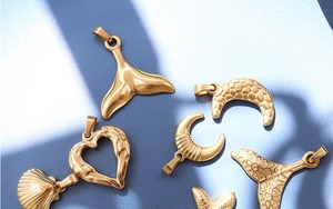Collection of golden sea-themed charms including starfish and whale tail on a blue background
