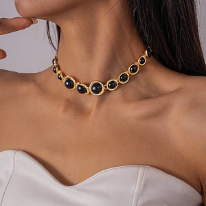 Detail of vintage gold choker necklace with black resin beads worn on neck model