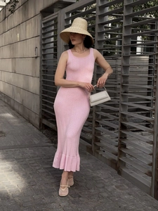 Détail d'une robe longue en maille rose sans manches avec motif texturé à vagues sur mannequin