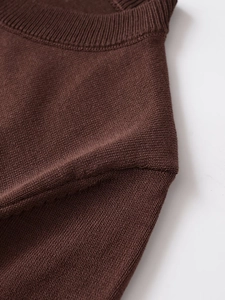 Detailed view of the ribbed round neckline and shoulder seam of the brown knit cardigan