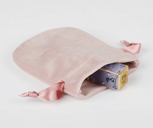 Detail showing pink velvet drawstring pouch texture with ribbon closure for cosmetics