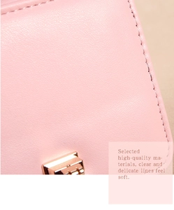 Gros plan sur le sac à main en cuir rose femme, belles coutures délicates et serrure métal.