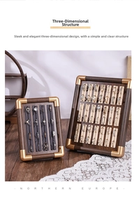 Macro view of walnut wood jewelry trays with gold metal corners and velvet ring slots