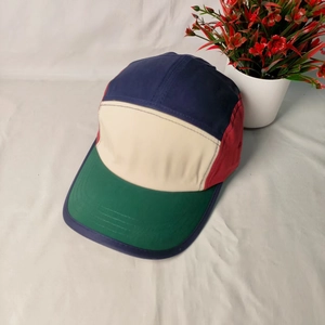 Detail of color-block canvas five-panel camper hat with navy, cream, and red panels