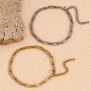 Detail of paperclip link anklets in gold and silver steel with lobster clasp