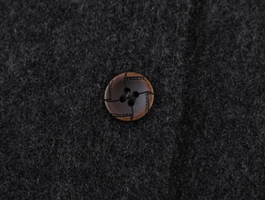 Detailed close-up of marble texture button on fuzzy knitted cardigan wool fabric