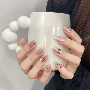 Detailed view of long coffin press-on nails with cat-eye finish and bow design