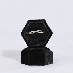 Close-up of golden pearl ring with pavé zircons in black velvet hexagonal jewelry box