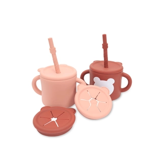 Detailed view of dual-handle silicone baby straw cups in pink and reddish brown colors