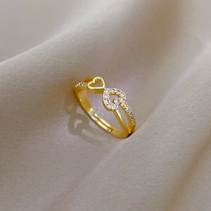 Detailed macro view of golden heart-shaped ring with zircon stones on velvet