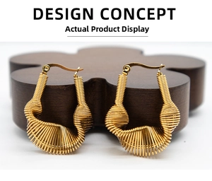 Detailed macro view of gold spiral textured hoop earrings on a dark decorative wooden tray
