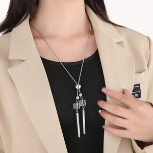 Detail of silver long tassel sweater necklace with transparent cubes and metal beads