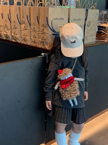 Kids outfit set featuring a brown crochet monster crossbody bag and grey sweatshirt