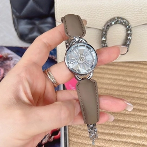 Close-up of a ladies' watch with a spinning diamond snowflake dial and brown leather strap
