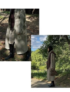 Detail view of a long beige coat with black boots and scarf in a stylish outdoor autumn setting