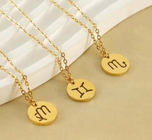 Vue détaillée de trois colliers zodiacaux dorés avec pendentifs Scorpion, Gémeaux et Vierge