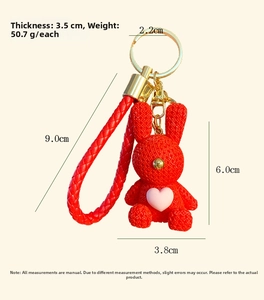Detail view of red resin rabbit keychain with size specifications and knitted texture