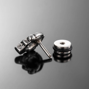 Macro shot of stainless steel skull stud earring with retro finish and screw back closure