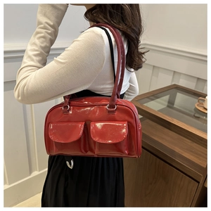 Detail of red patent leather shoulder bag with double front flap pockets and vintage style