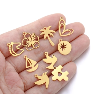 Golden stainless steel tropical flower and animal charms set held in hand for jewelry making