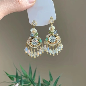 Detail of bohemian long tassel earrings with colorful rhinestones and floral motifs