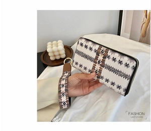 Detail of long wallet zipper and wristlet strap with ethnic geometric patterns