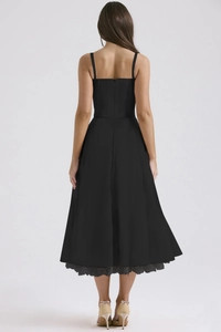 Detail of black midi dress showing delicate lace hemline and woven fabric texture