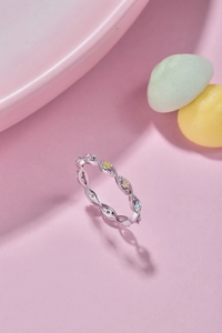 Macro shot of silver woven ring band set with multi-colored cubic zirconia stones