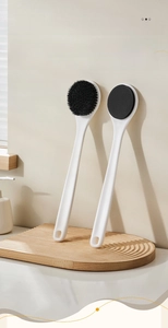 Close-up of bamboo charcoal fiber bath brush and lotion applicator with long handles