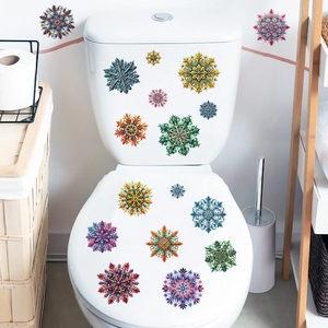 Colorful snowflake mandala stickers set on a white toilet lid in a clean bathroom setting
