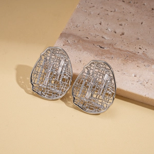Detailed macro view of silver geometric hollow earrings with vertical crystal stones