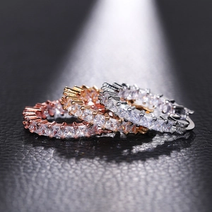 Macro shot of three stacked eternity bands with square-cut cubic zirconia in gold and rose gold