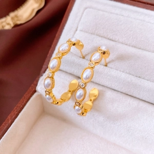 Macro detail of 18K gold plated C-shape earring with pearl and crystal in velvet box