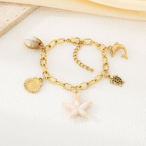 Détails des breloques étoile de mer et coquillage dorées 18k sur un bracelet marin