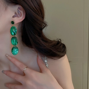 Détail de longues boucles d'oreilles vintage en acrylique vert émeraude géométrique