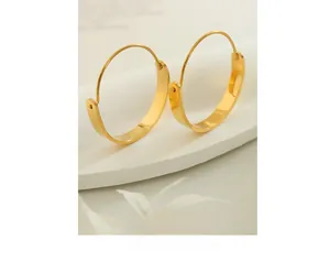Detailed view of gold plated geometric hoop earrings on minimalist display stand