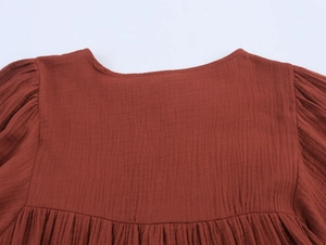 Detail of embroidered neckline and cotton gauze texture on summer long sleeve casual dress