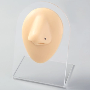 Detailed view of a black star shaped stainless steel nose stud on a realistic nose model