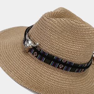 Close-up of woven straw Panama hat with ethnic band and silver bull skull metal ornament