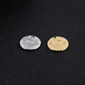 Close-up of gold and silver stainless steel evil eye pendants for jewelry making