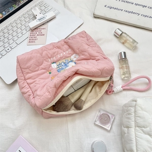 Detailaufnahme der rosa gesteppten Kosmetiktasche mit Herzmuster und Stickerei